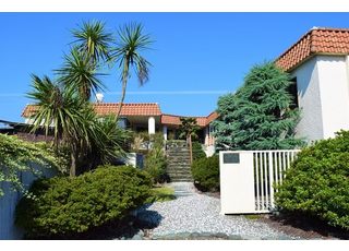 駐車場にある青い看板と、オレンジの瓦屋根が目印です。