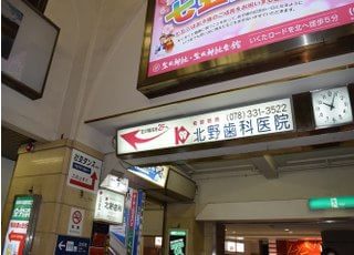阪急 神戸三ノ宮駅を出てエスカレーターを降りますと当院の看板がございます。