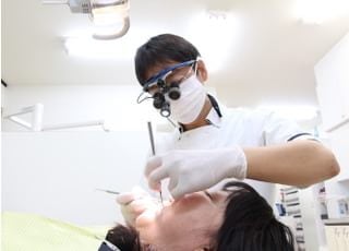拡大鏡を使用して精密な治療を行っています